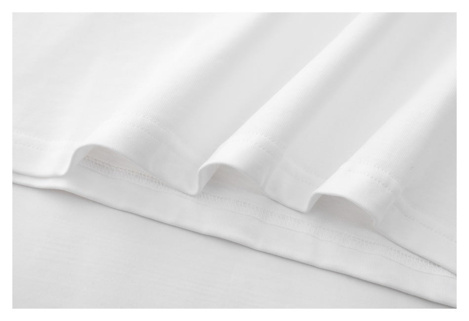 Close-up of the white T-shirt's lower hem, showing the folded edge and stitching.