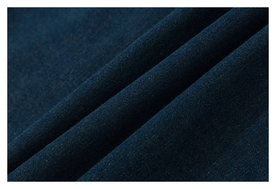 Macro view of dark blue denim fabric arranged in soft folds.