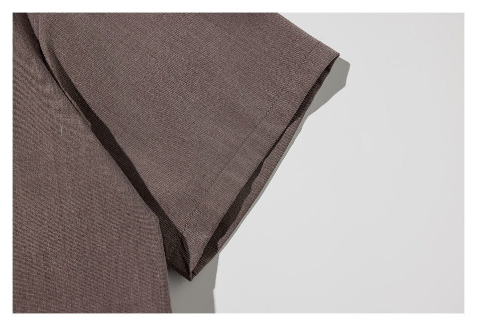 Close-up of the taupe shirt's short sleeve and stitched hem.