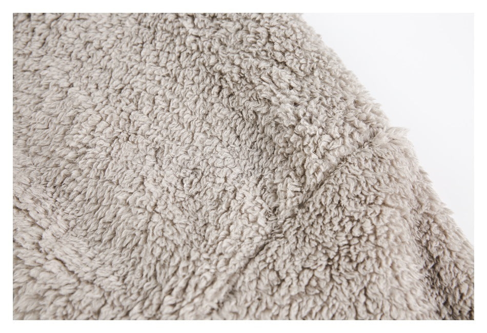 Close-up of light beige, thick curly-pile fabric against a white background.