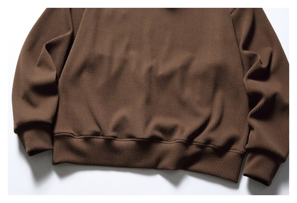 Front view of a brown ribbed hooded sweatshirt laid flat, with long sleeves and ribbed cuffs and hem.