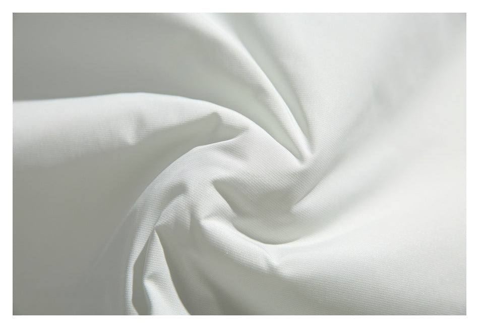 Close-up of smooth white jacket fabric gathered into soft folds.