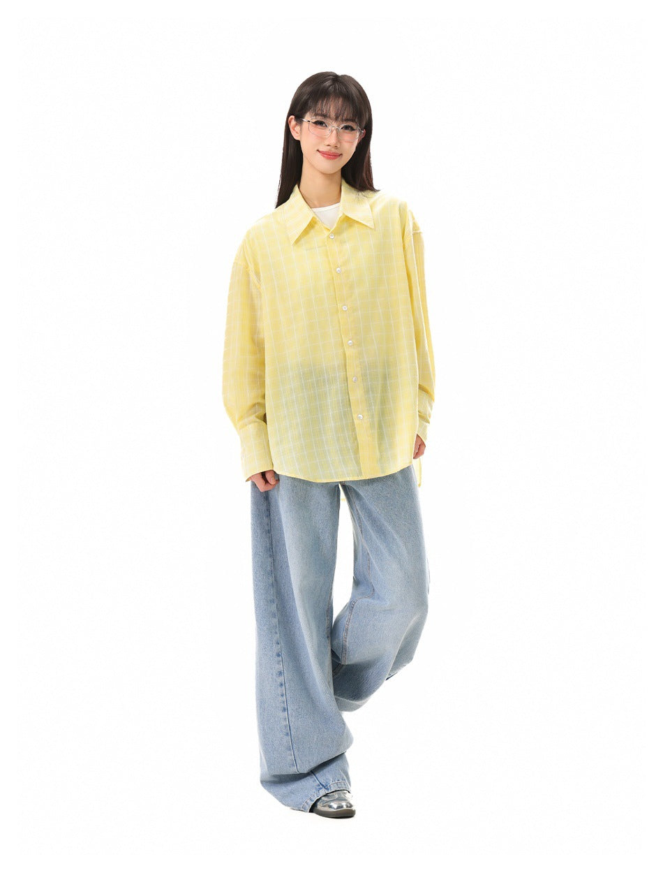Full-length model wearing an oversized yellow windowpane-check button-up shirt with wide-leg blue jeans.
