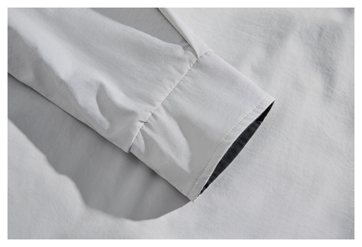 Close-up of a light gray garment sleeve cuff with visible stitching and dark inner lining.