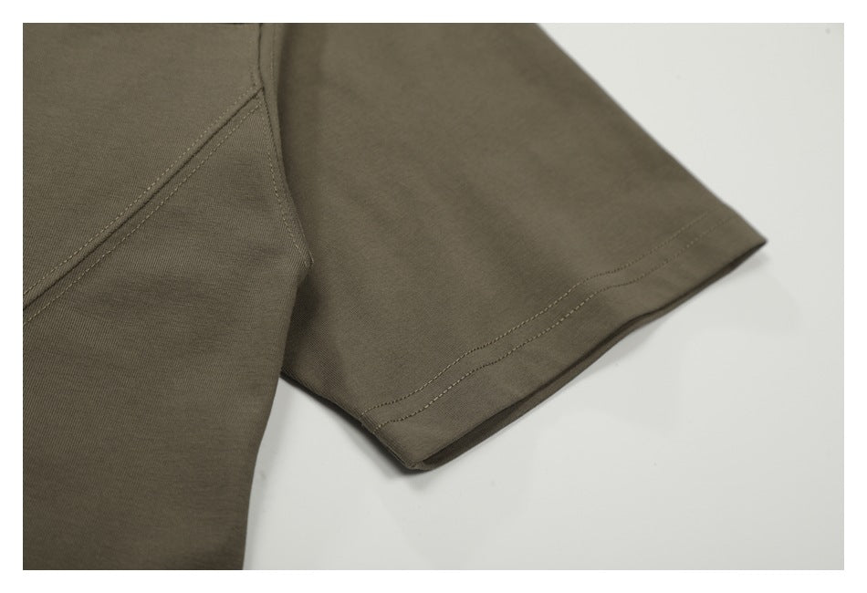 Close-up of the olive-brown T-shirt's short sleeve and double-stitched hem.