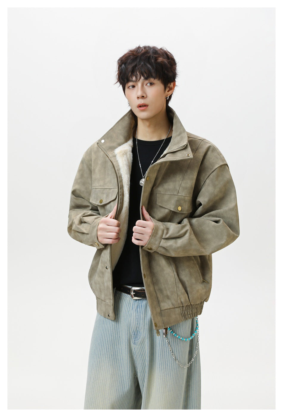 Model wearing an oversized olive-gray jacket with a high collar, flap chest pockets, and pale lining.