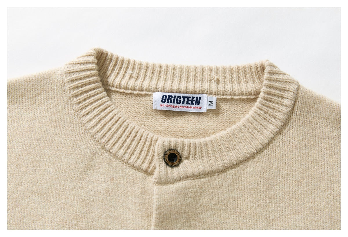 Close-up of a cream knit cardigan's ribbed round neck, front button, and sewn-in ORIGTEEN size label.