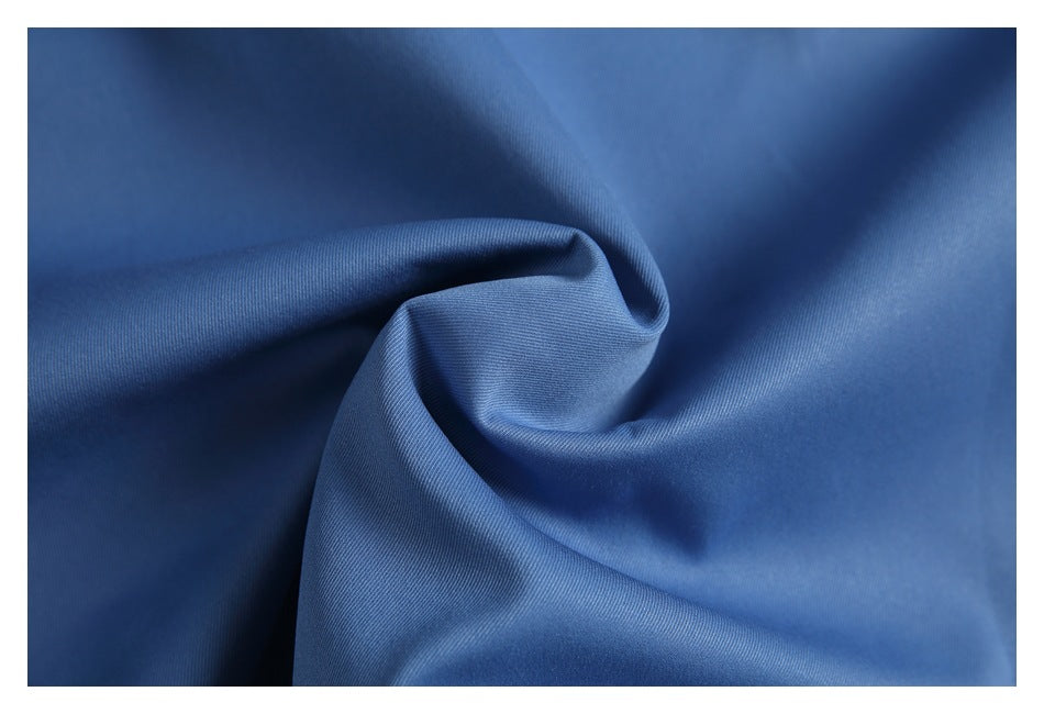 Close-up of blue fabric gathered into soft folds, showing its surface texture.