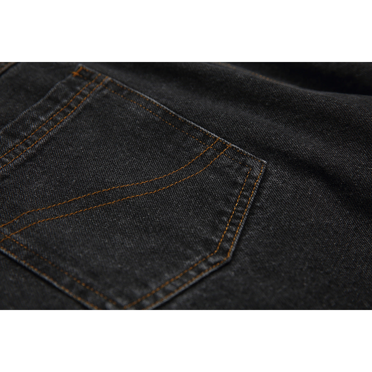 Close-up of a back pocket on black denim jeans with orange-brown topstitching.