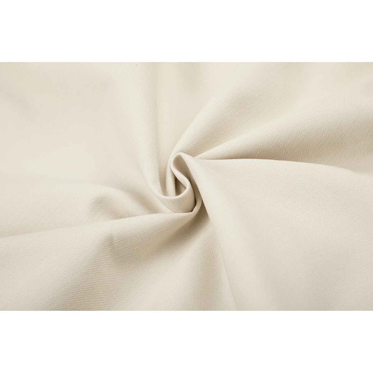 Close-up of ivory fabric gathered into soft folds, showing its fine surface texture.