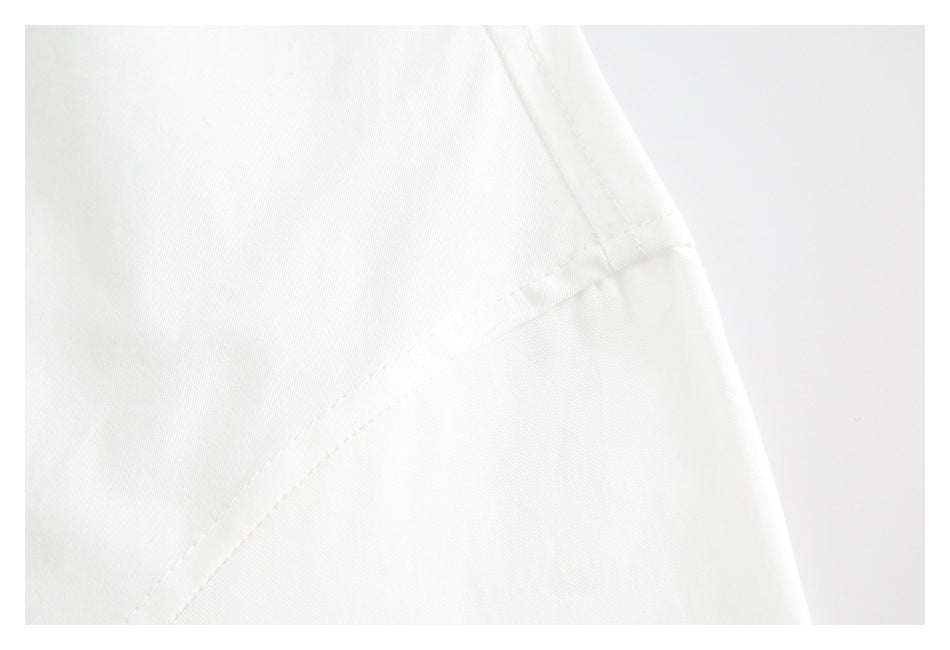 Close-up of white garment fabric with a curved stitched seam.
