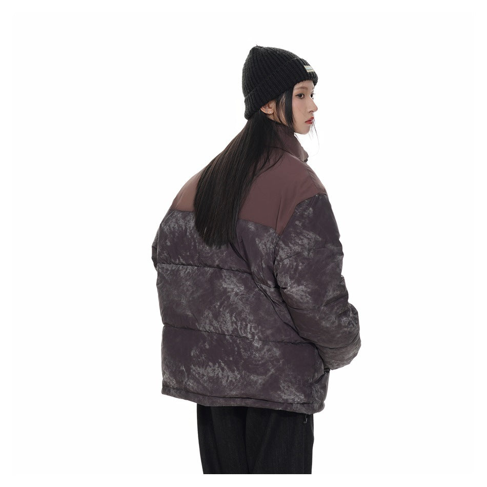 Three-quarter rear view of a model wearing the plum and charcoal mottled puffer jacket.