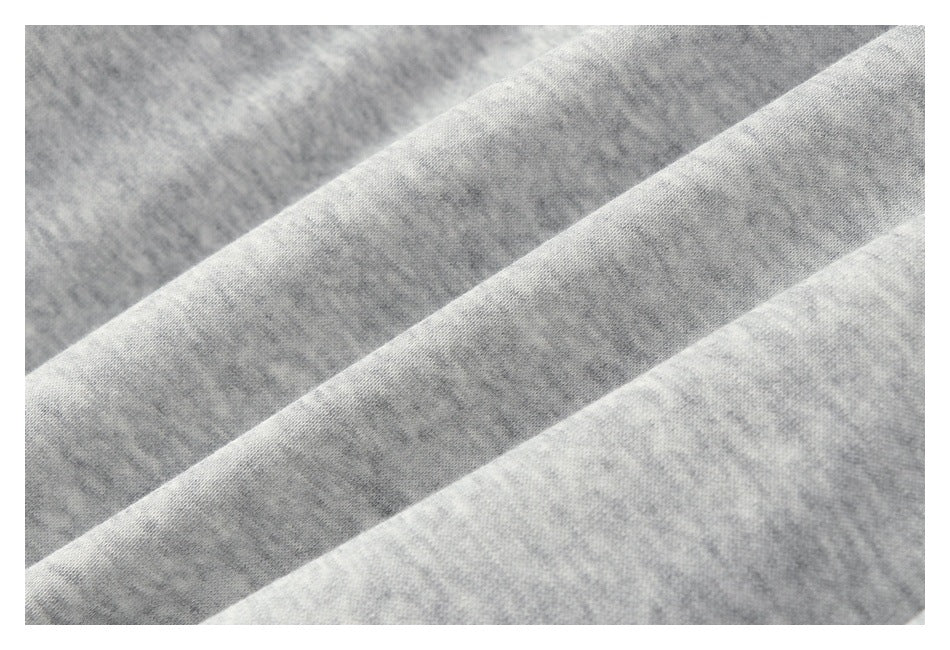 Close-up of light gray heathered knit fabric arranged in soft diagonal folds.