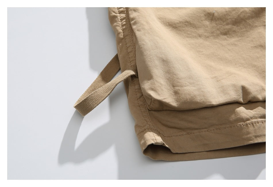 Close-up of a tan cargo pocket, hem and side strap.