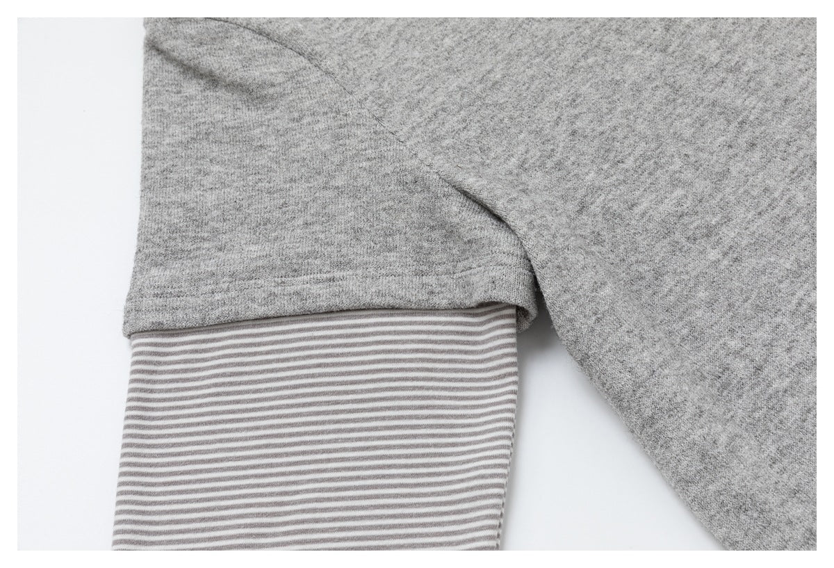 Close-up of a heather gray sleeve with a gray-and-white striped inner cuff.