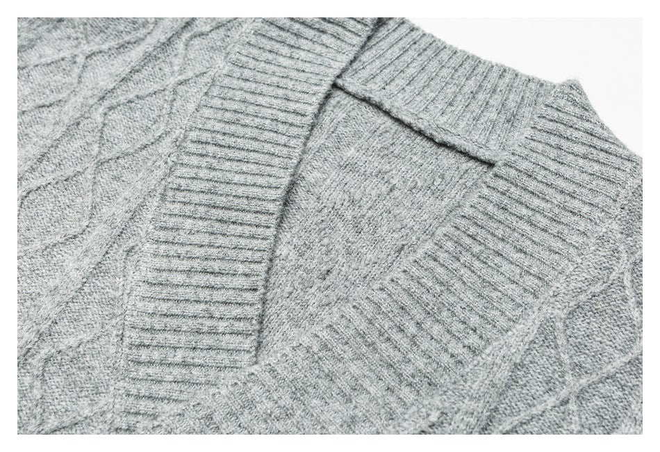 Close-up of a gray cable-knit sweater neckline and ribbed collar.