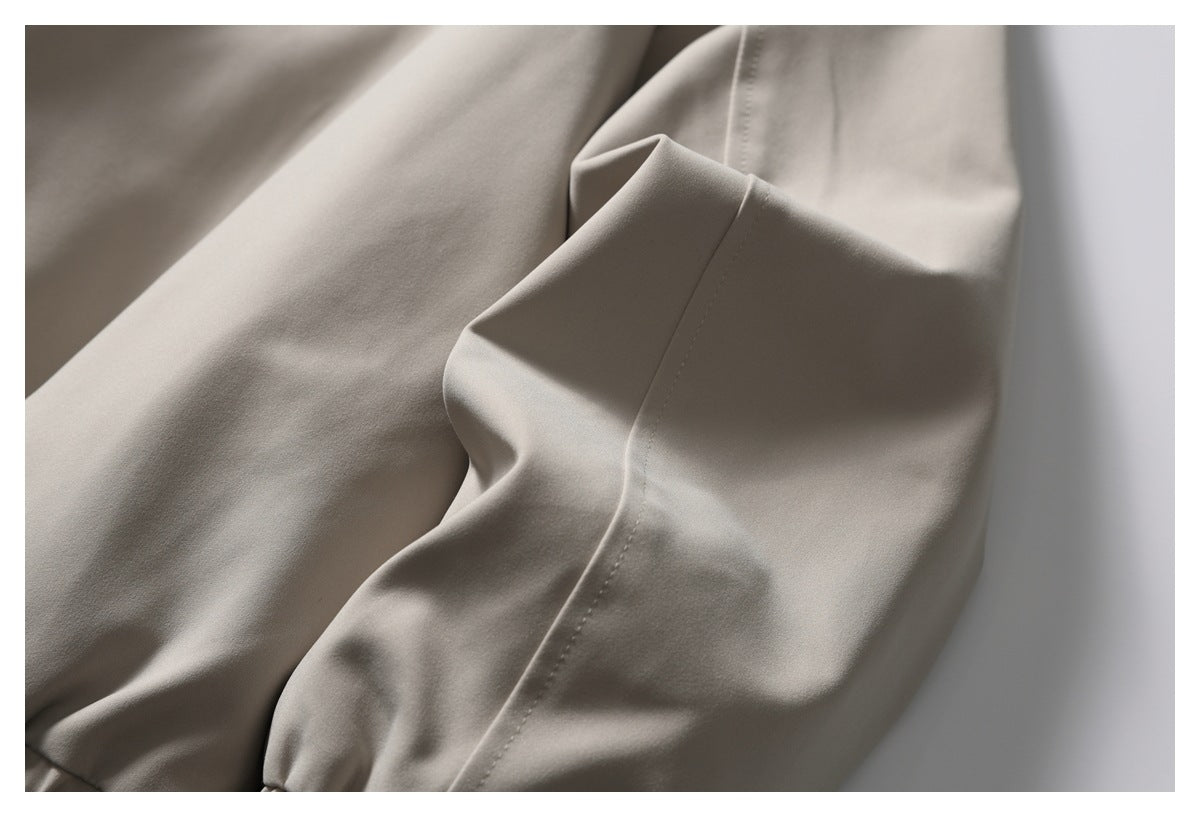 Close-up of a sleeve seam on the light taupe jacket.