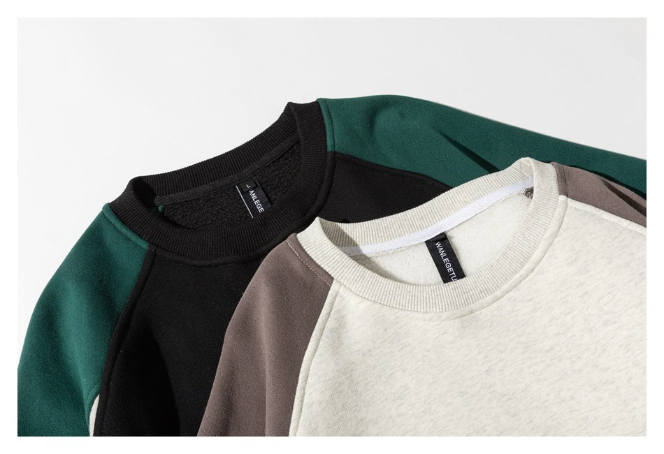 Close-up of two color-block sweatshirts showing their crew necks and shoulder panels in black-green and oatmeal-charcoal.