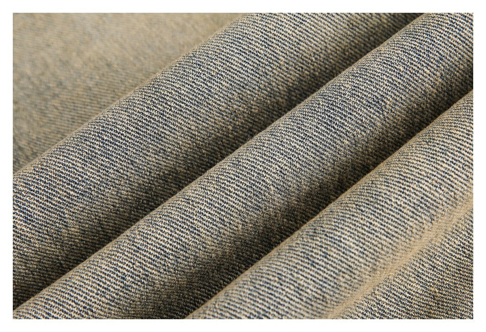 Macro view of folded tan denim showing its diagonal twill weave.