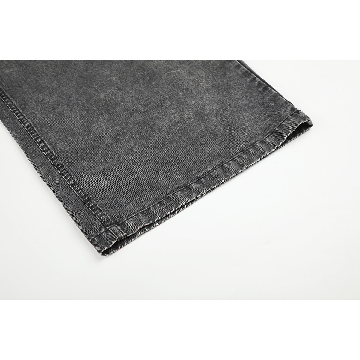 Close-up of a wide charcoal-gray denim leg showing the stitched hem and side seam.