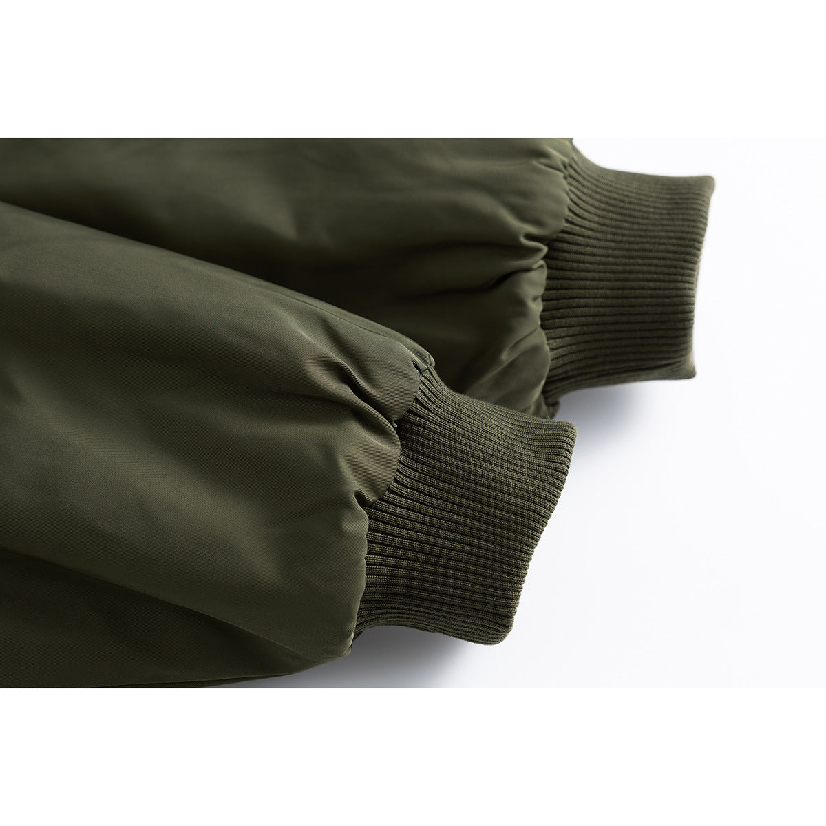 Close-up of two olive bomber jacket sleeves with rib-knit cuffs.