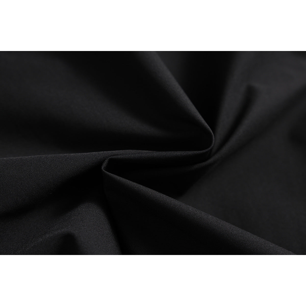 Close-up of black fabric arranged in folds, showing its surface texture.
