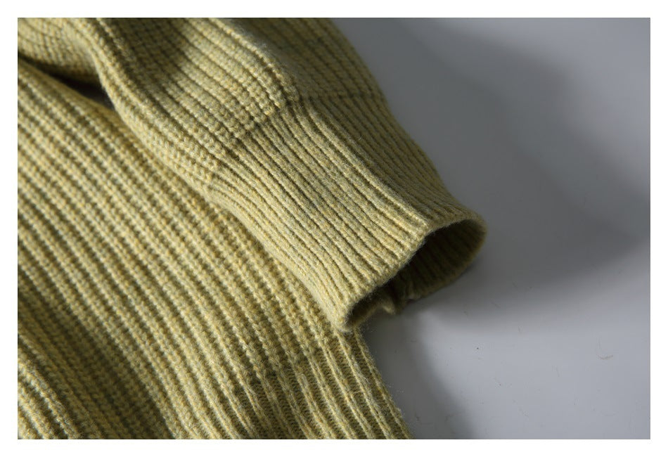 Close-up of the olive-beige sweater's ribbed sleeve cuff and knit texture.