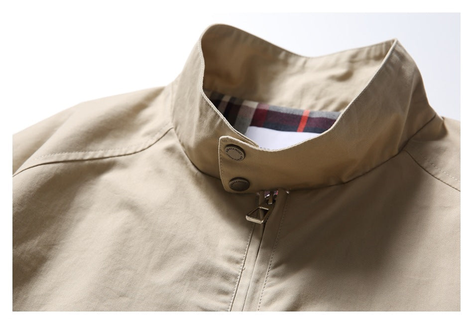 Close-up of the beige jacket’s stand collar, front zipper, buttons, and plaid inner lining.