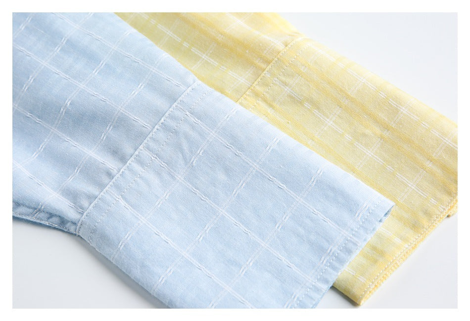 Close-up of light blue and pale yellow checked shirt cuffs, showing stitching and the grid pattern.