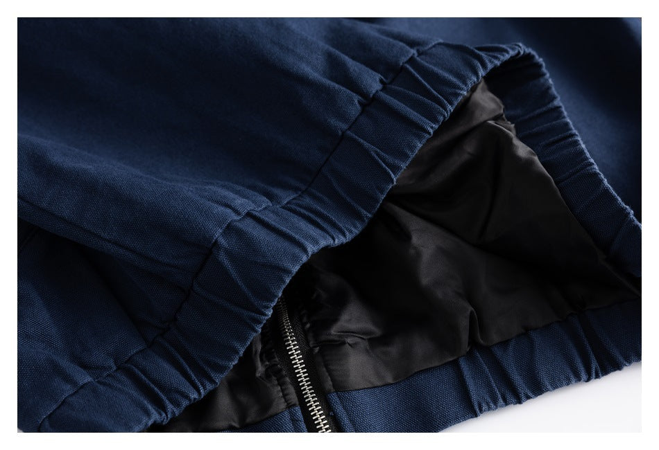 Close-up of navy garment fabric, black lining, a zipper, and a gathered seam.