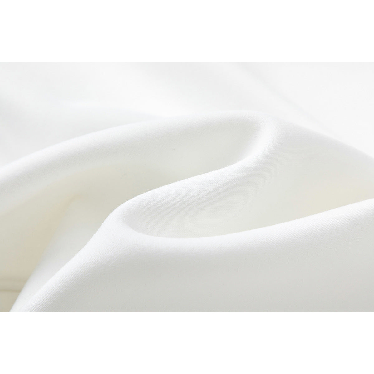 Close-up of softly folded white sweatshirt fabric showing its surface texture.