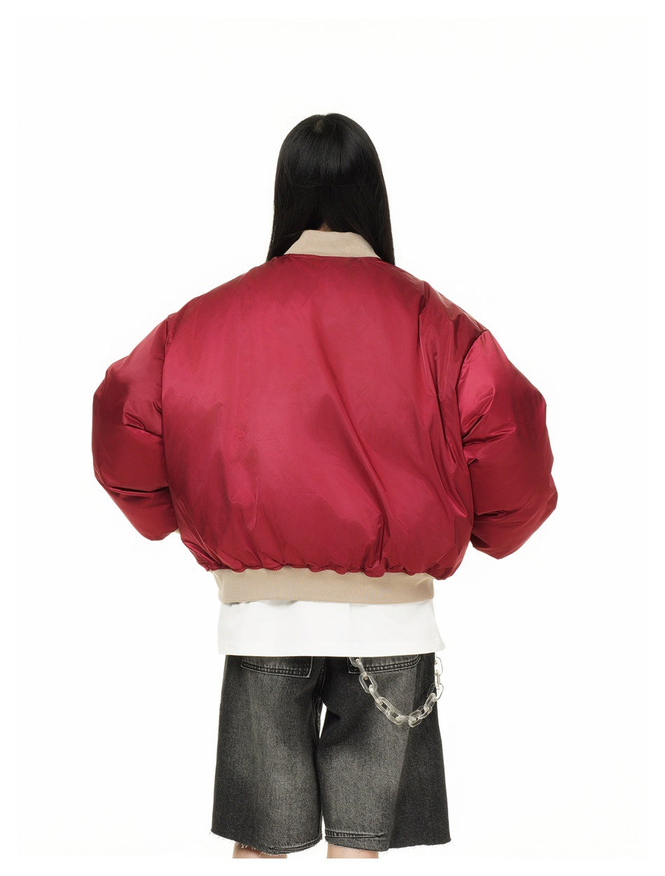 Model viewed from behind wearing a red oversized jacket with beige ribbed collar and hem.
