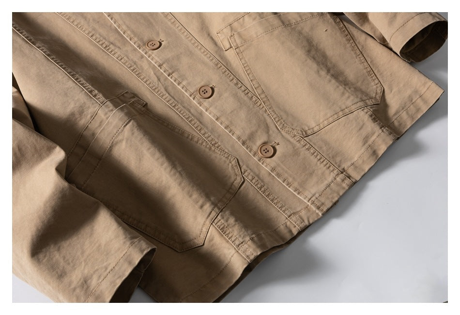 Angled close-up of the tan jacket front, showing buttons, two large pockets, stitched panels, and hem.