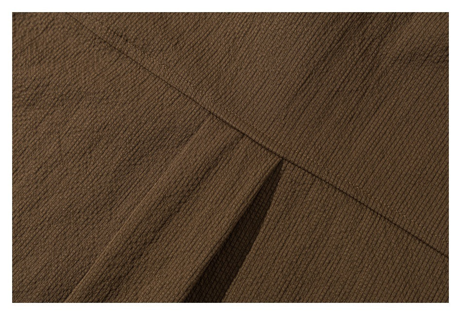Close-up of the brown shirt's stitched seam and textured fabric.