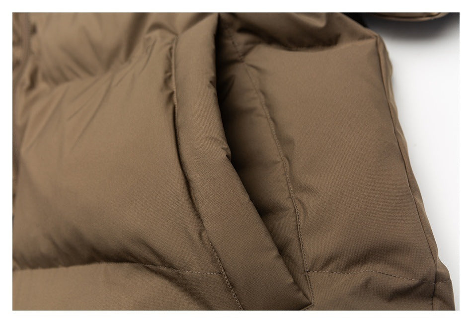 Close-up of a brown jacket's stitched front pocket and panel seams.