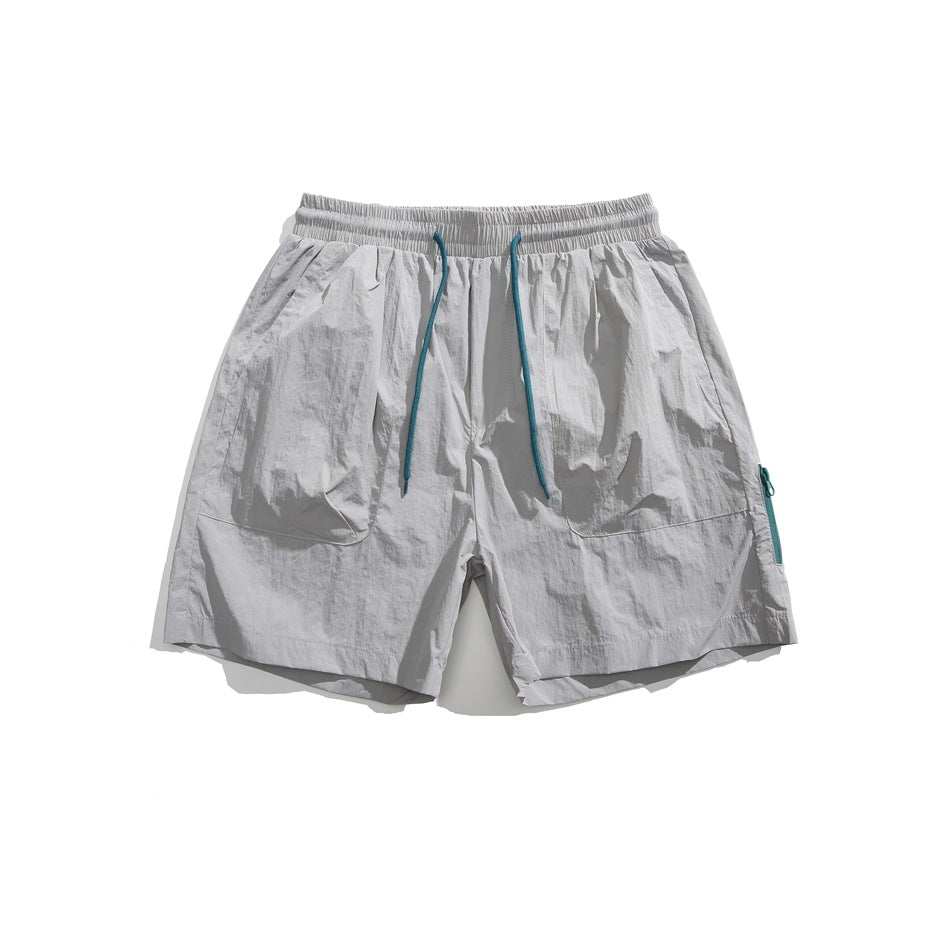 Light gray drawstring shorts with teal cord, front patch pockets and teal side zipper, flat lay front view