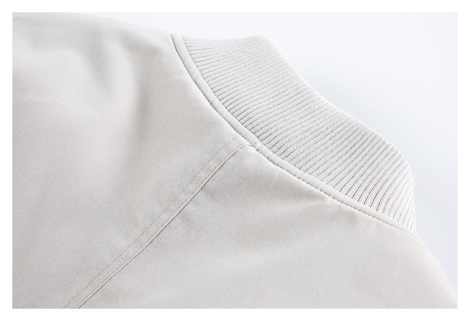 Close-up of a ribbed band joined to smooth pale gray-beige fabric with visible stitching.