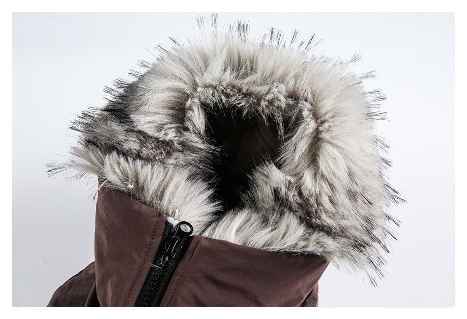 Close-up of a dark brown jacket hood trimmed with long gray and cream faux fur, showing the front zipper.