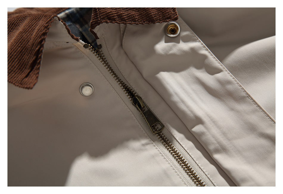Close-up of the beige jacket's front zipper, snap fasteners, and brown corduroy collar.