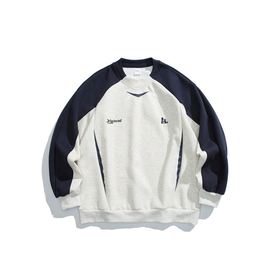 Front of an ivory crewneck sweatshirt with navy raglan sleeves, side accents, and small chest graphics.
