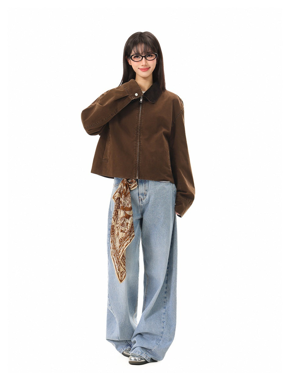 Model wearing a brown cropped zip jacket with dark collar and cuffs, paired with wide-leg light blue jeans.