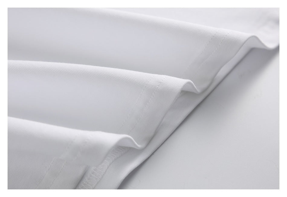 Close-up of white garment seams and folded hems, with stitching visible along the edges.