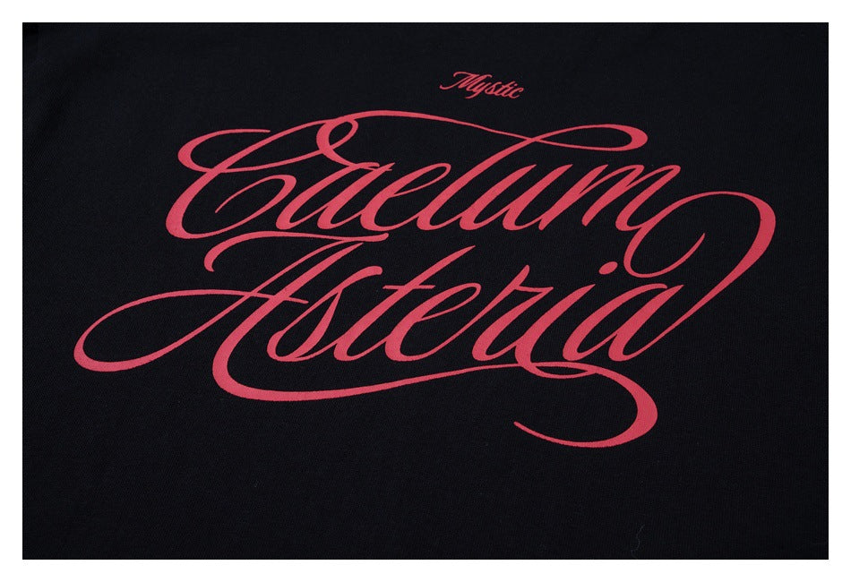 Close-up of large ornate red script with smaller lettering printed on black fabric.