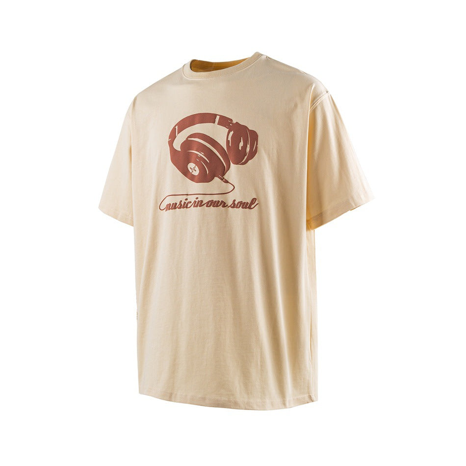 Front view of a cream short-sleeve T-shirt with a brown headphone graphic and “Music in our soul” text.