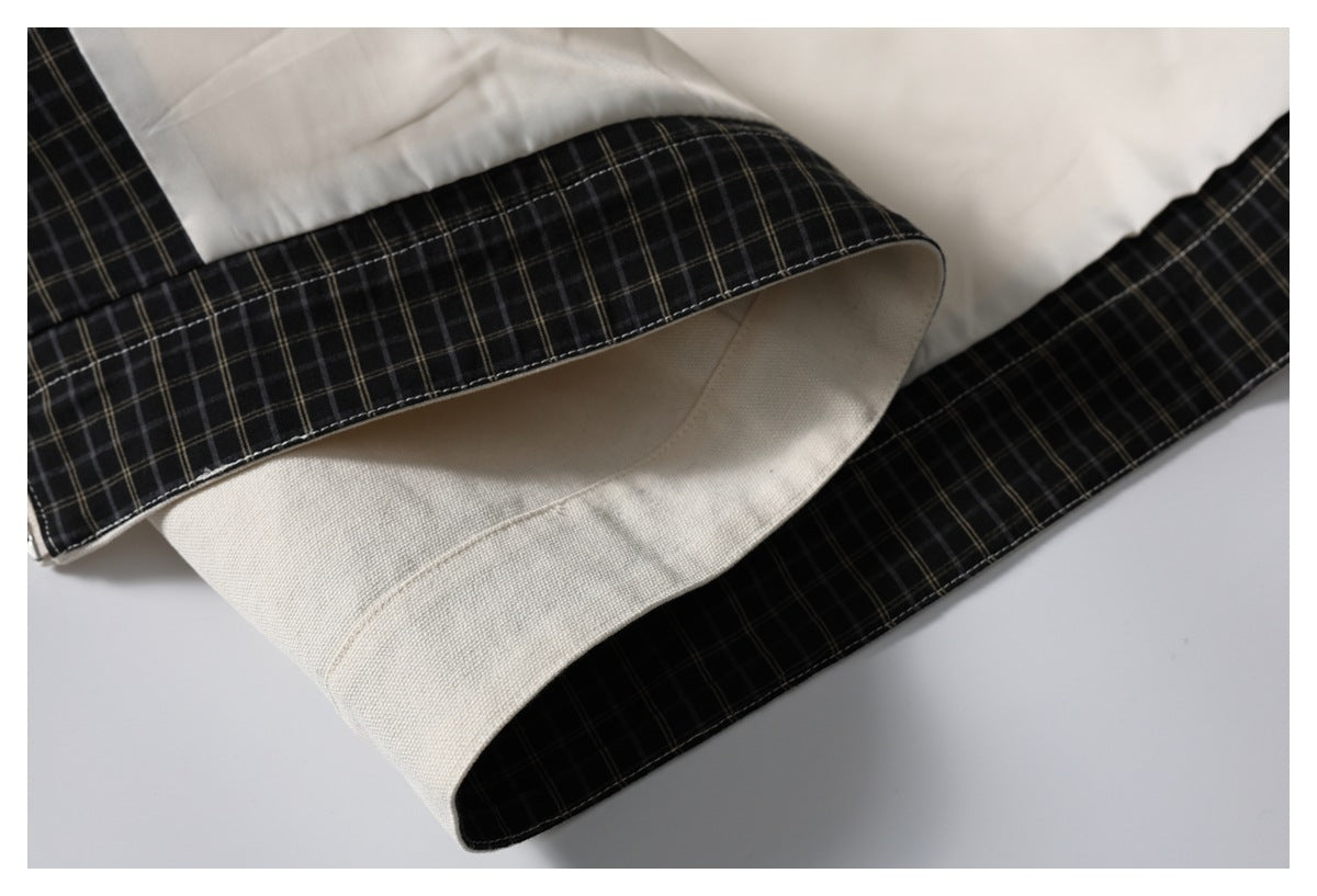 Close-up of the jacket hem with a black plaid band and ivory fabric on the inside.