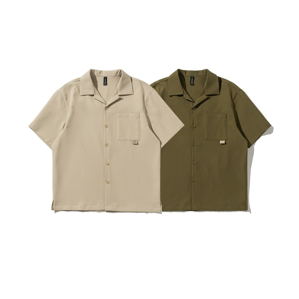 Front view of beige and olive short-sleeve button-up shirts, each with a collar and chest pocket.