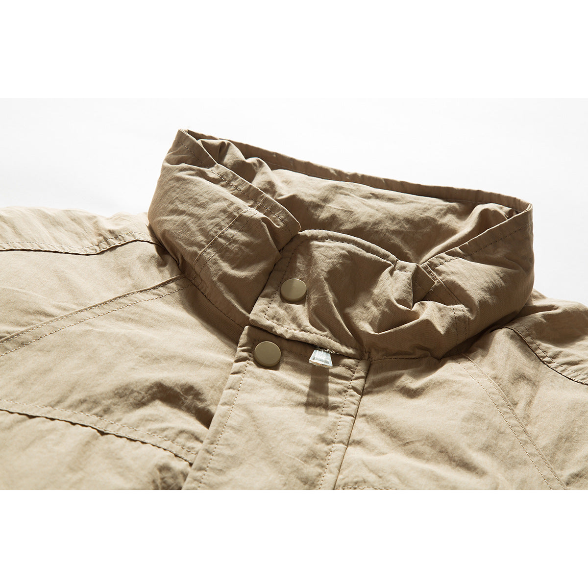 Close-up of a tan jacket collar and snap-button placket with visible topstitching.