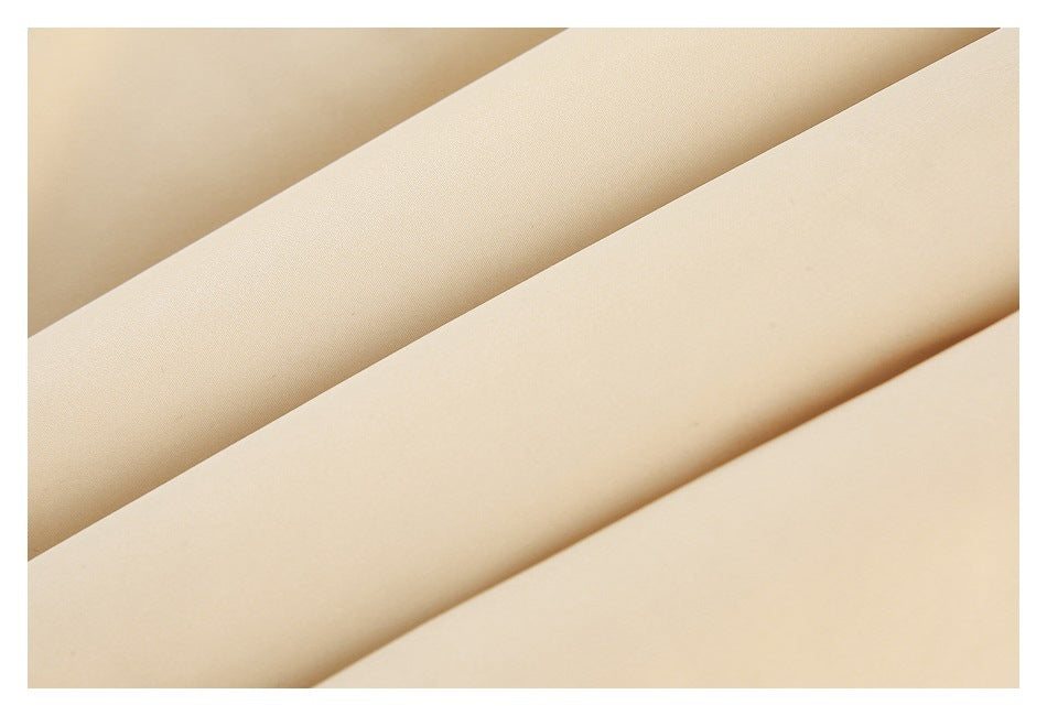 Close-up of beige fabric arranged in overlapping folds, showing its surface texture.