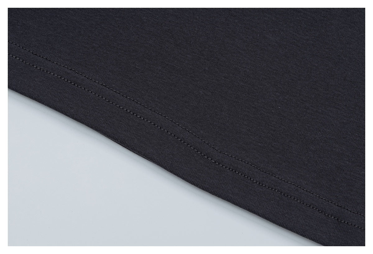Close-up of a charcoal garment's stitched hem and fabric edge.