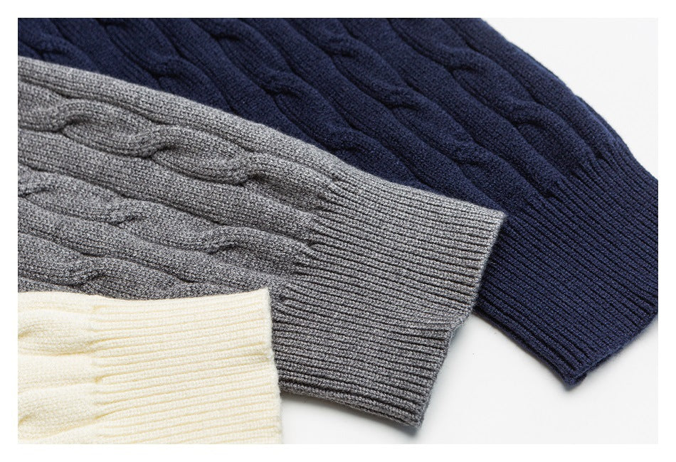 Close-up of cable-knit sweater cuffs in ivory, gray, and navy.